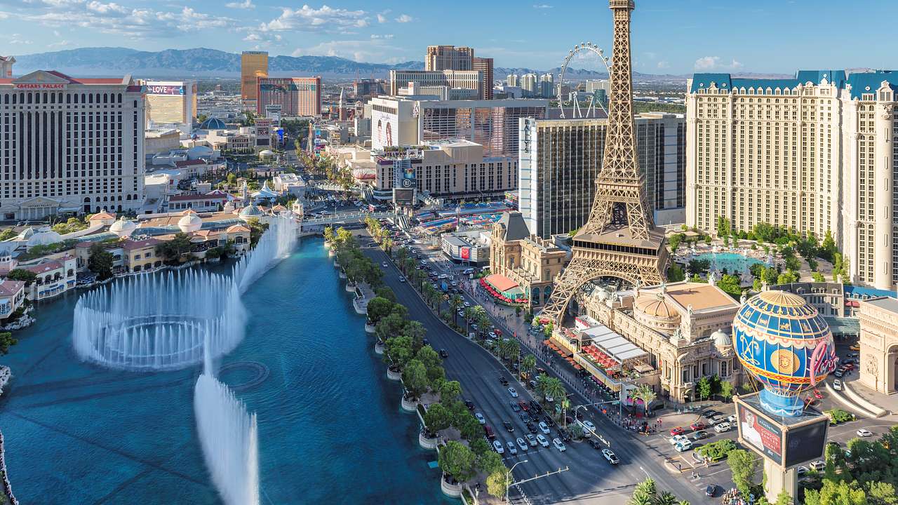 A view of the Vegas strip with buildings, a fountain, and an Eiffel Tower replica