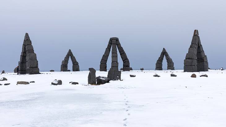 Arched and pyramid structures made of black blocks on the snow