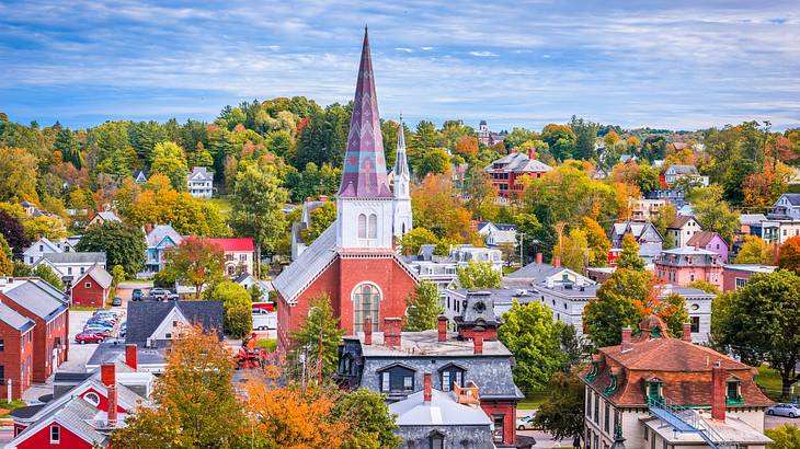 A view of Montpelier, Vermont, with white and red buildings, a chapel, and fall trees