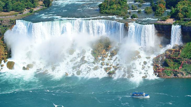 The powerful Niagara Falls from above with a boat on bottom right, Ontario, Canada The powerful Niagara Falls from above with a boat on bottom right, Ontario, Canada