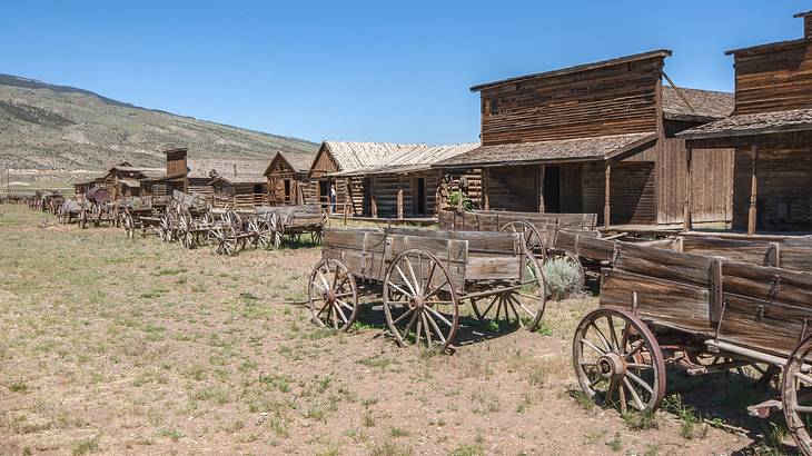 Old-fashioned wooden wagons next to small wooden buildings in a ghost town