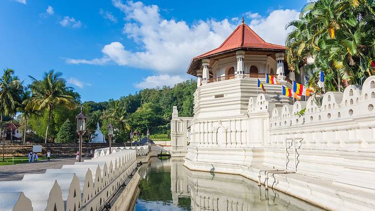 Temple of the Tooth with a red roof and a red roof surrounded by water