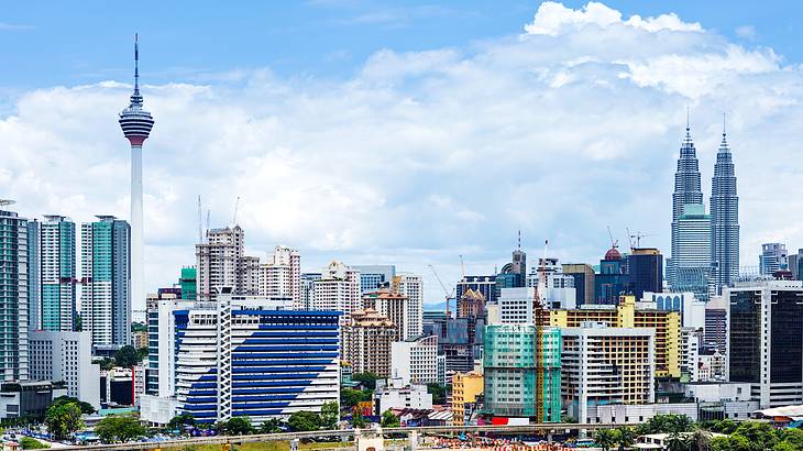 Aerial view of a tall tower in the midst of city buildings and green trees