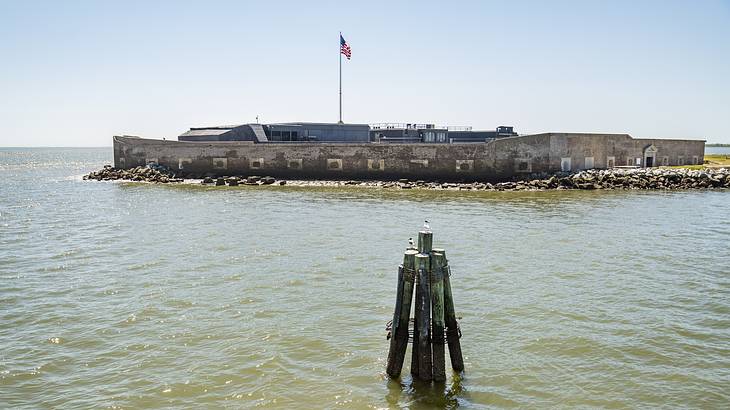 A walled sea fort on an island displaying the American flag A walled sea fort on an island displaying the American flag