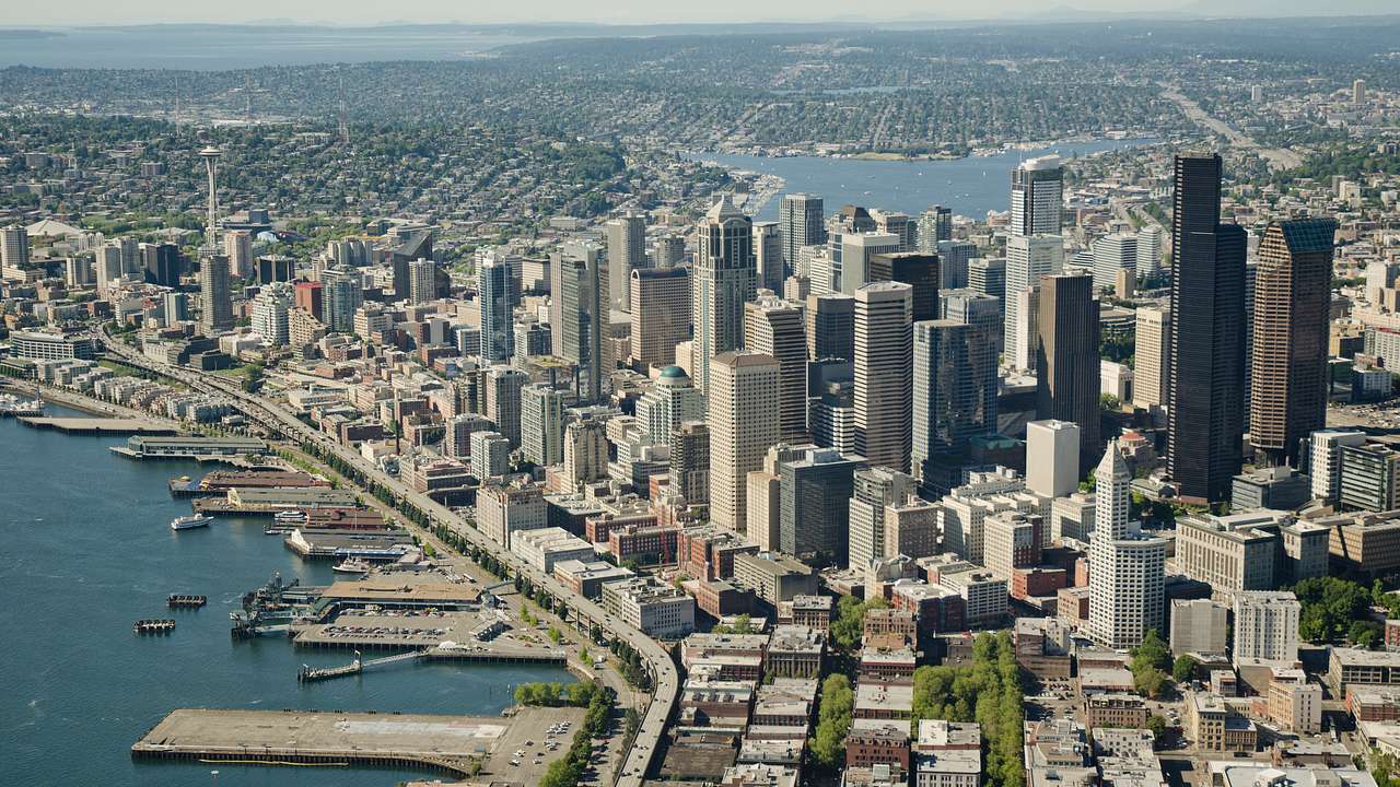 Aerial shot of a city with tall skyscrapers and bodies of water