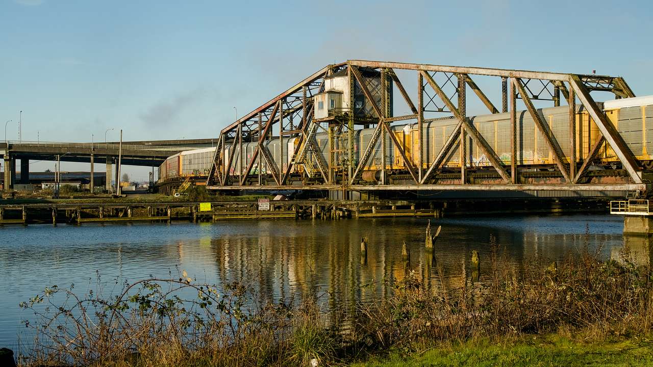 A train traversing an old railroad bridge over a body of water