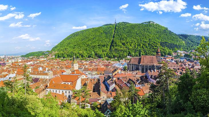 View over building tops surrounded by green hills, Brasov, Romania