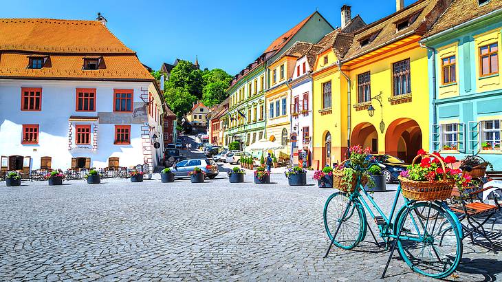 A square lined with colorful houses and a bicycle in Sighișoara, Romania