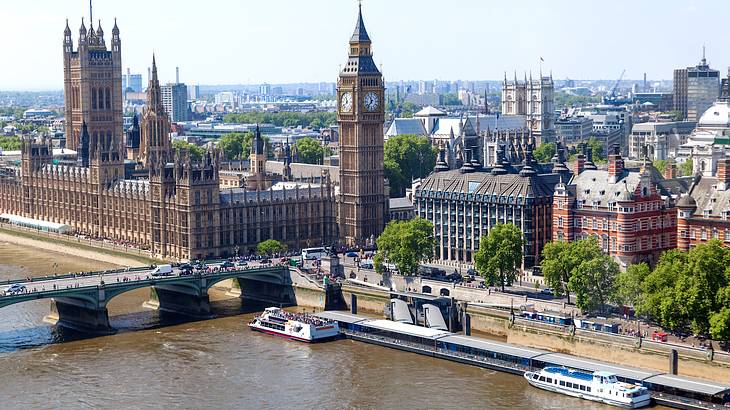 Aerial city view of buildings, a clock tower, and a bridge over water, London, UK