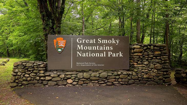 A sign saying "Great Smoky Mountains National Park" next to trees
