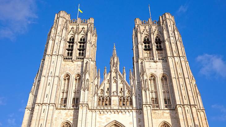 A white Gothic cathedral building against a blue sky with light clouds