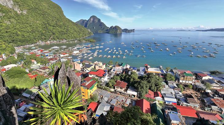 A coastal town from above surrounded by boats and mountainous islands