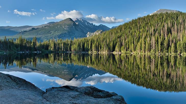 A lake with forests and a greenery-covered mountain in the background