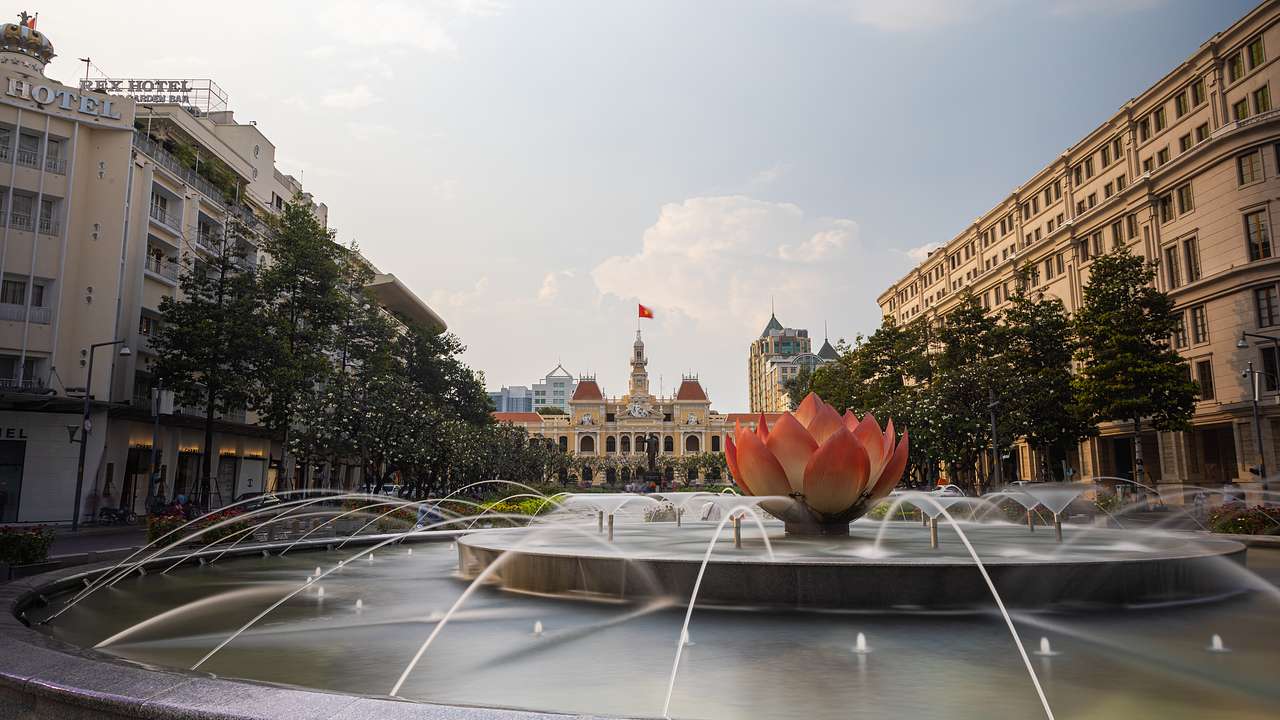A fountain with a modeled flower at its center, surrounded by trees and buildings