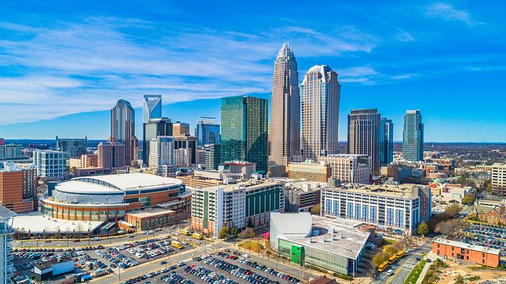 A city with a parking lot in front of many buildings under a blue sky