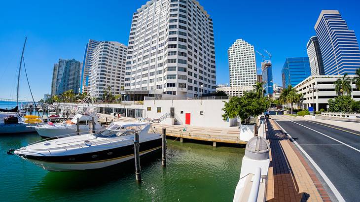 A speedboat docked on a pier with buildings in the background under a blue sky