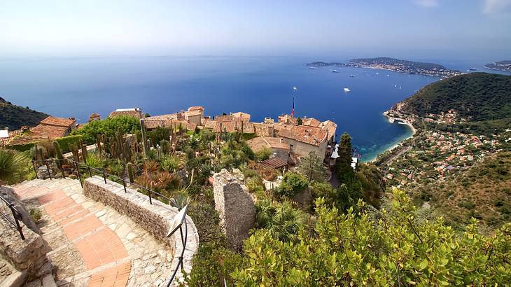 Aerial view of a French town on a cliff overlooking very blue water, Nice