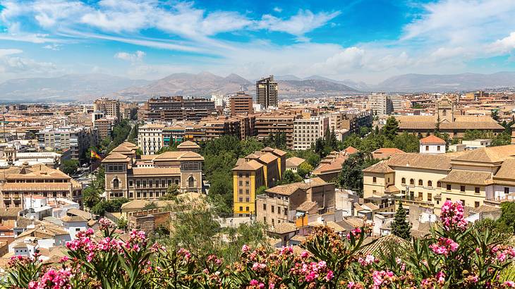 A panoramic view of a city with multi-colored historical buildings and mountains