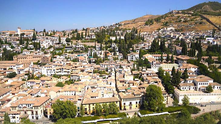 Overlooking a historic town on a clear blue day with a green hill on the right