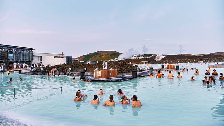 A milky blue pool with people in it under a blue sky