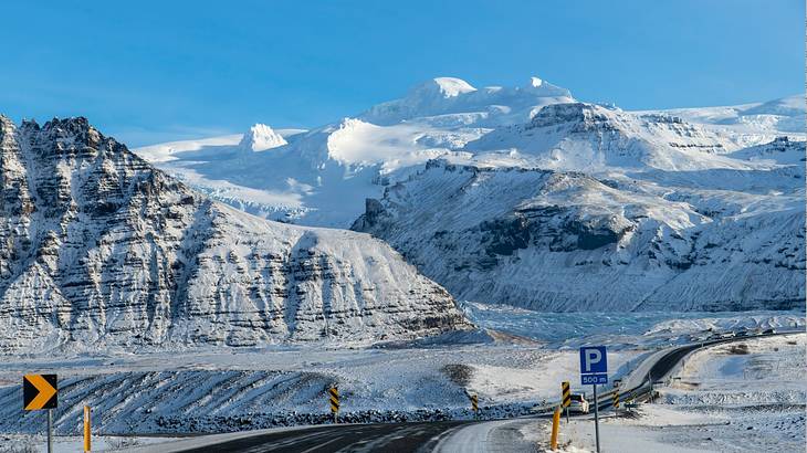 Ice formation and glaciers stretching out against snowcapped mountains on a sunny day