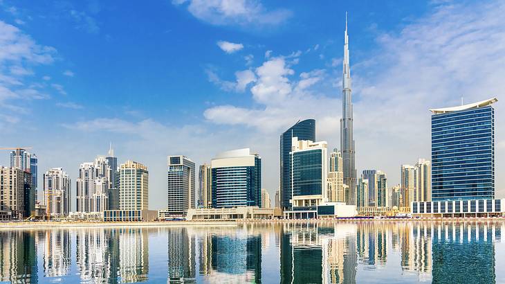 A modern city skyline with tall buildings and Burj Khalifa next to the water