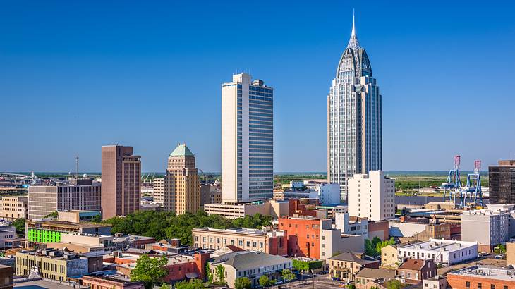 Skyscrapers, among other buildings and greenery, in a city skyline on a clear day