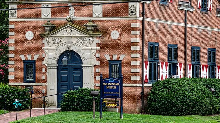 A red brick building with a stone doorway and a sign that says "Zwaanendael Museum"