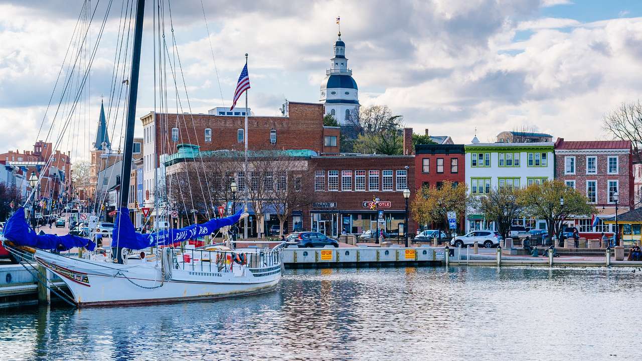 A boat on the water next to buildings in Annapolis on a cloudy day