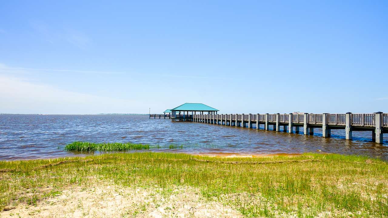 A pier extending into an ocean on a clear day