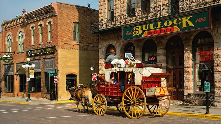 An old-fashioned wagon next to a hotel with a "Bullock Hotel" sign