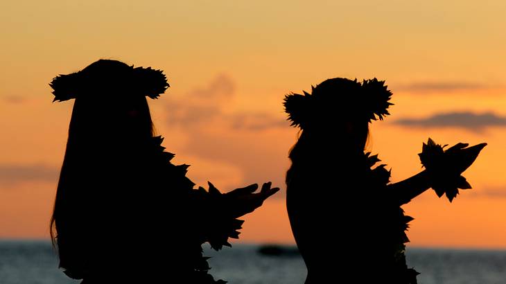 Silhouettes of luau dancers in Maui, Hawaii at sunset, USA