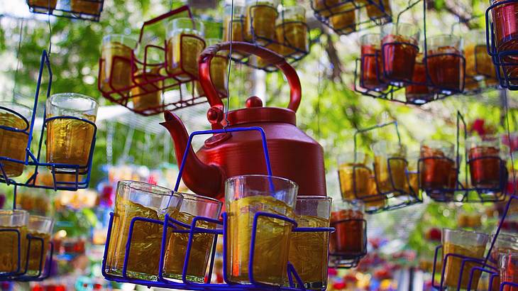 Focused photo of a hanging kettle and tea glasses displayed at a market