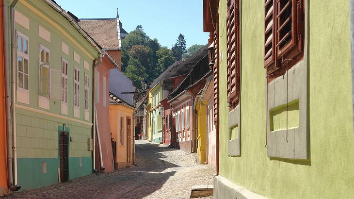 A street lined with colourful houses on each side in Sighișoara, Romania