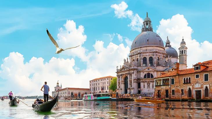 A gondola passing by a structure with a dome-shaped roof and houses