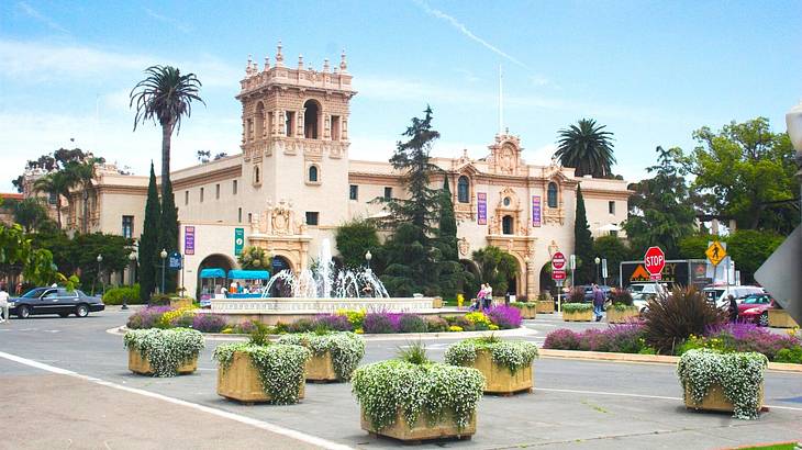 A castle-style building with palm trees and other plants in front of it