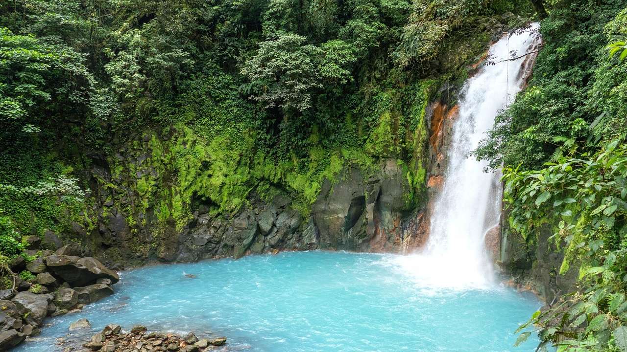 A waterfall flowing into a pool in Tenorio Volcano National Park