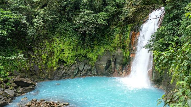 A waterfall flowing into a pool in Tenorio Volcano National Park