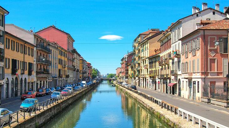 A canal with colourful buildings and streets on either side of it