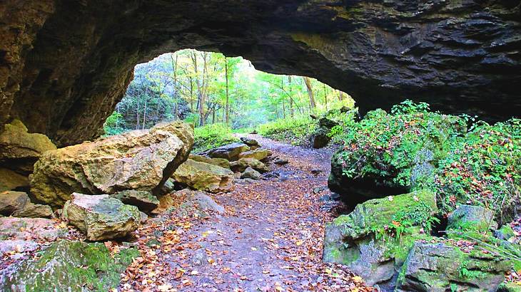 A walkway surrounded by rocks with a natural bridge above