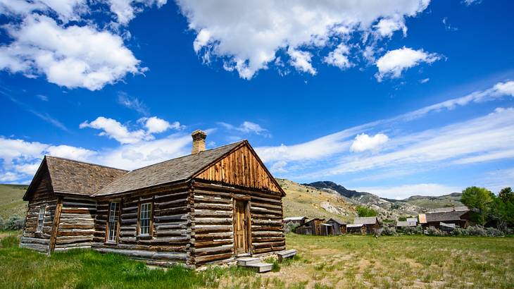 Abandoned wooden cabins on a grassy hillside on a sunny day Abandoned wooden cabins on a grassy hillside on a sunny day