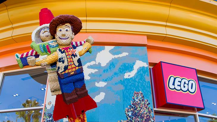 Lego figures from Toy Story on the front of a store with a Lego sign