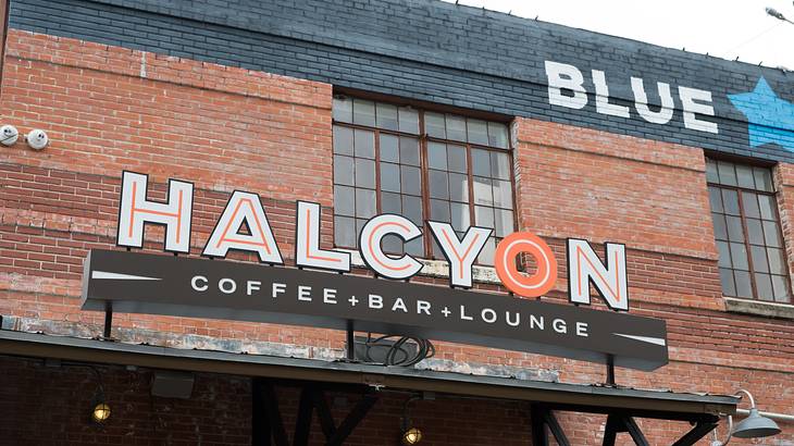 A red-brick building with a signboard saying "Halcyon Coffee+Bar+Lounge"