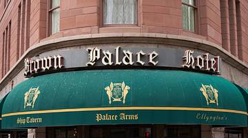 A "Brown Palace Hotel" sign above a green and gold awning on a building