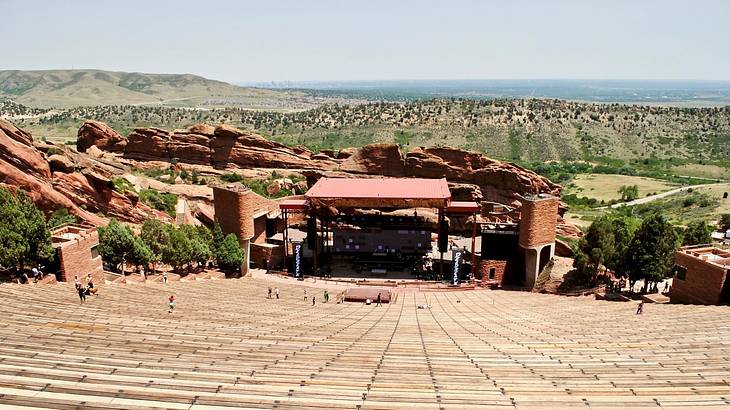 Steps and a theatre built into red rock in a green mountainous surrounding