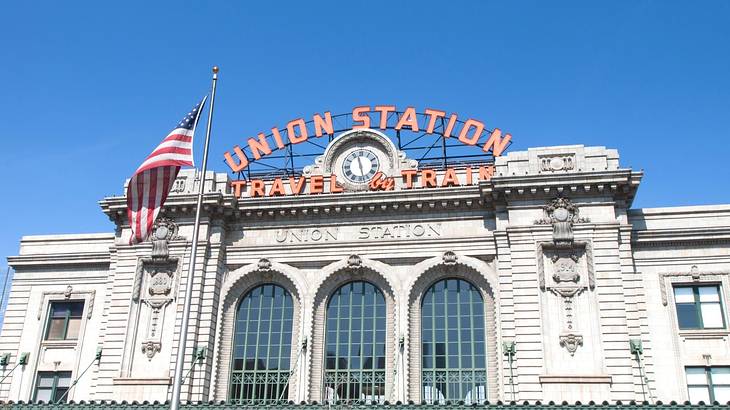 A stone building with glass windows and a "Union Station" sign on it