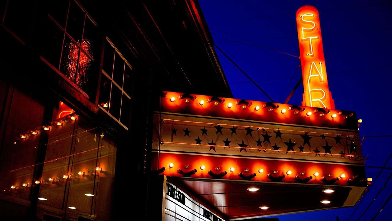 An orange neon movie theatre sign named "Star" lit up at night