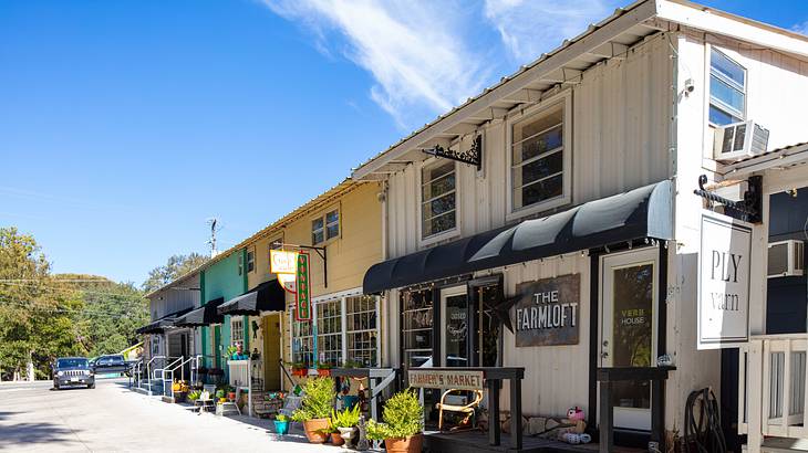 A line of short colorful shop buildings with awnings in front, on a nice day