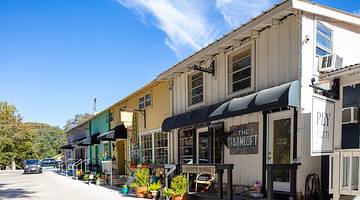 A line of short colorful shop buildings with awnings in front, on a nice day