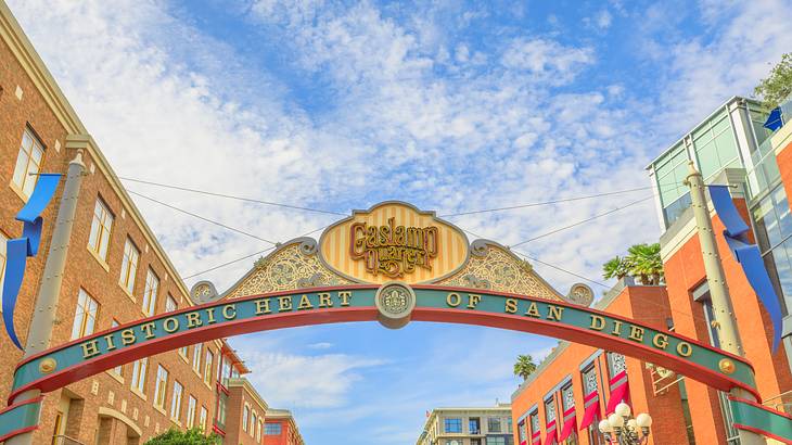 A sign that says "Gaslamp Quarter" with buildings on either side under blue sky